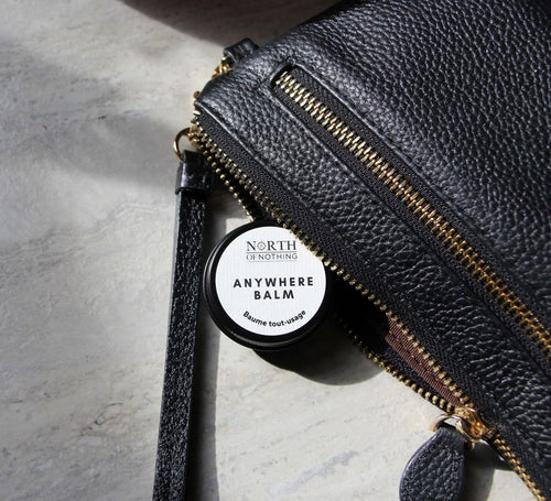 North of Nothing Anywhere Balm tucked inside a black leather bag.